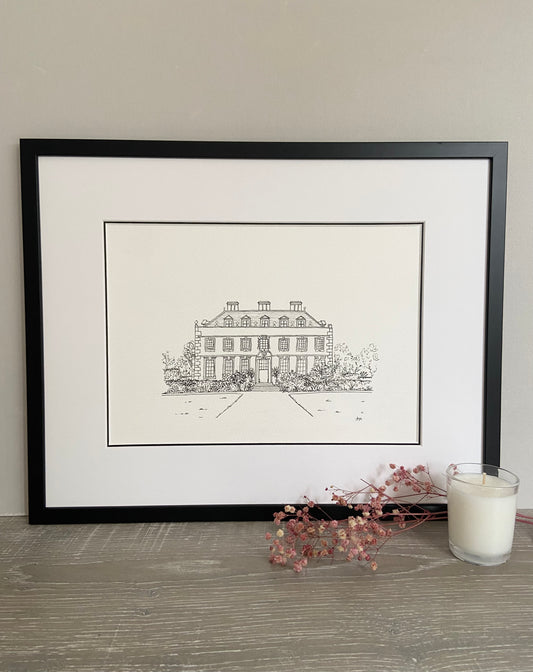 A framed hand-drawn line illustration of a wedding venue. Black line drawing on white paper with a black frame and a double mount