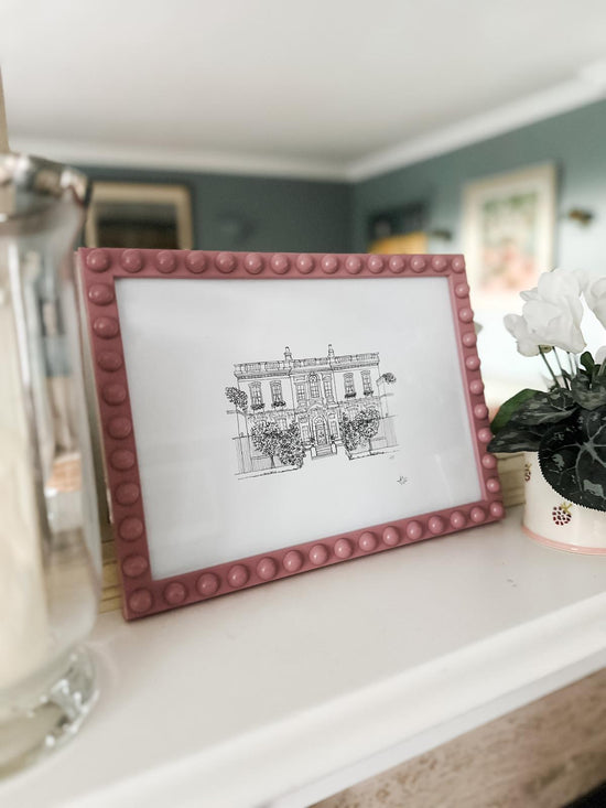 Bridgerton Print in a pink bubble frame in the mantelpiece of a customers home.