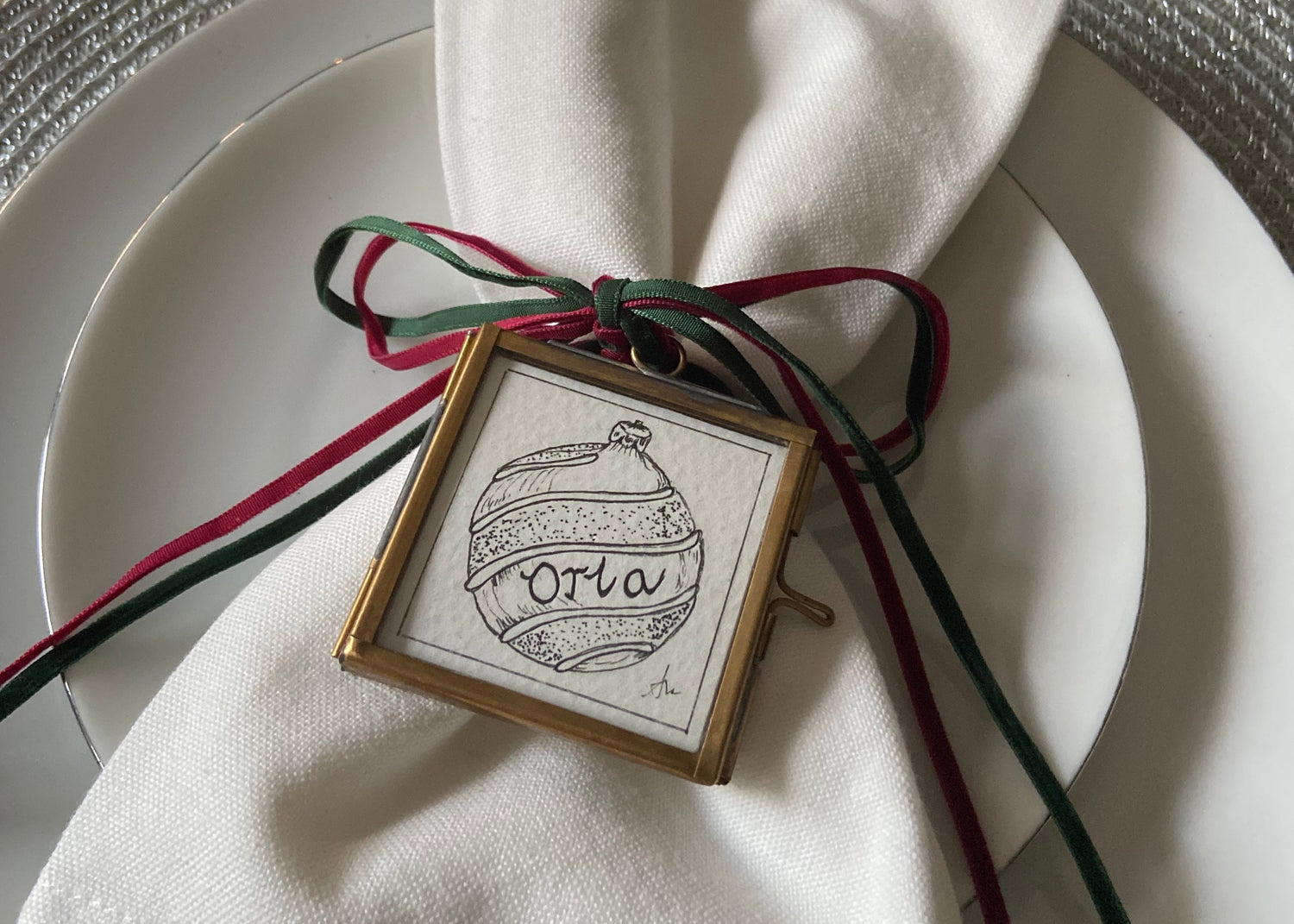 Decorative ornament with 'Oria' on a white plate with a napkin