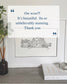 Framed black and white house illustration with decorative elements on a shelf.