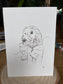 Sketch of a dog on a white card with a wooden surface and plant in the background