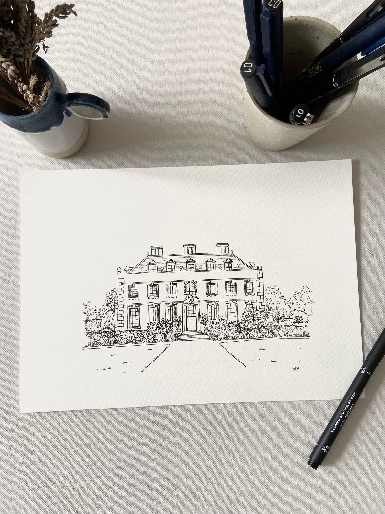 Hand drawn original black and white illustration of St Giles Wedding Venue on a table with a pen resting to the side